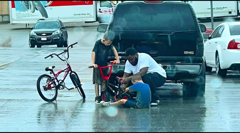 This man noticed two kids walking in the pouring rain one of them pushing a broken bicycle